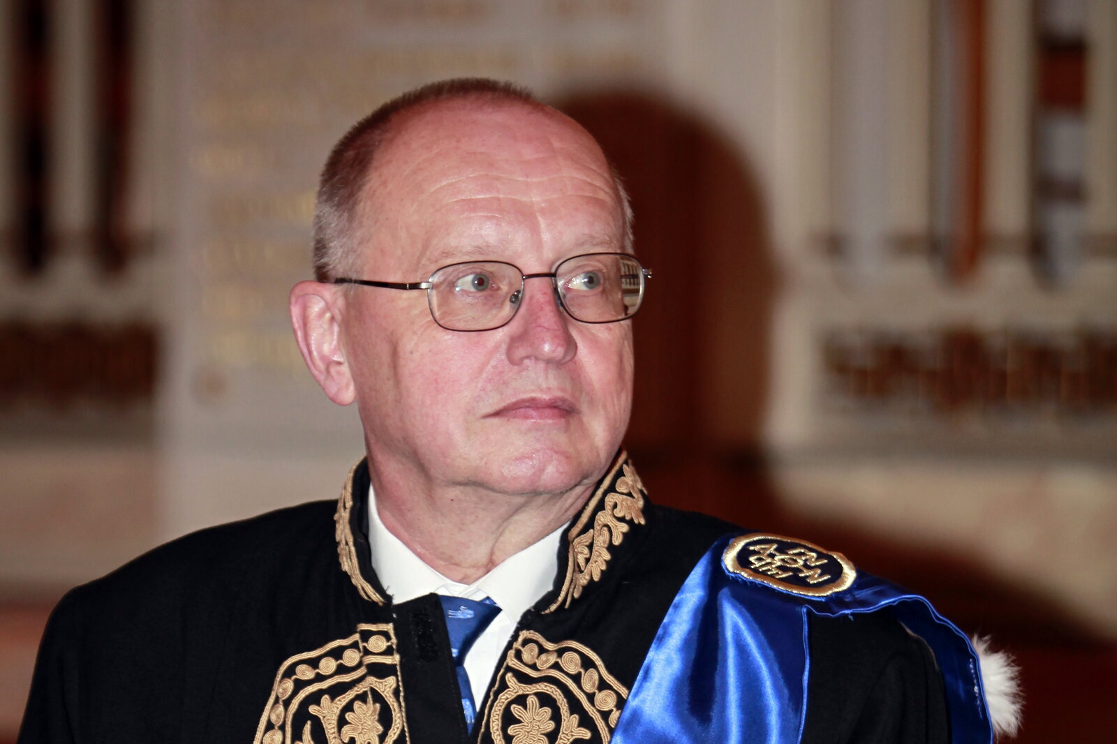 Ein Mann mit Brille schaut nach rechts.