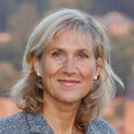 Eine Frau mit schulterlangem Haar lächelt in die Kamera.