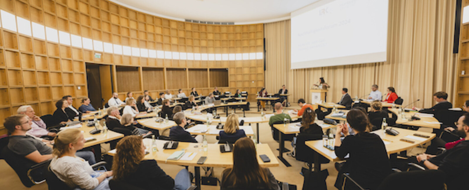 Nachhaltigkeitsforum 2024: Männer und Frauen sitzen im Vortragssaal der Akademie. 