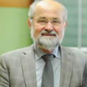 Ein Mann mit randloser Brille lächelt in die Kamera.