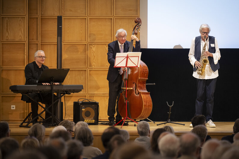 Drei Musiker spielen auf einer Bühne.