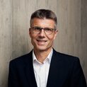 Ein Mann mit Brille lächelt in die Kamera.