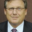 Ein Mann mit Brille schaut freundlich in die Kamera. Er trägt eine Krawatte.