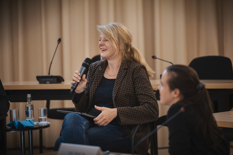 Eine Frau spricht in ein Mikrofon.