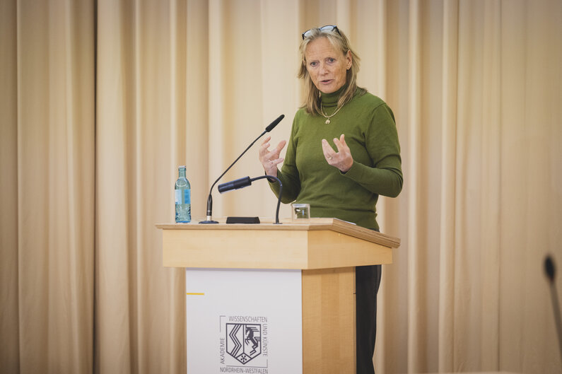 Eine Frau steht an einem Rednerpult.